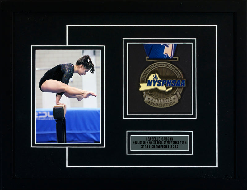 Framed picture: 12" x 16" with a medal, nameplate, and picture of a gymnast on a balance beam. 